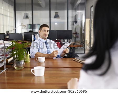 caucasian HR manager looking at a female candidate during an interview.