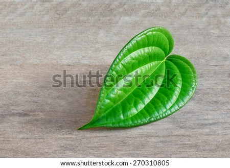 Shaped green betel  leaf heart shape on wood