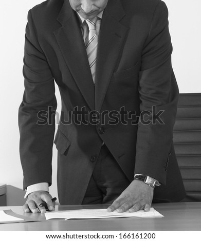 Business man signing contract or agreement vertical black and white