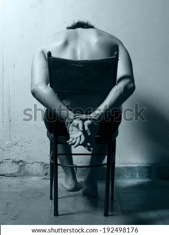 Tortured man in a chair with cold tones. Vertical