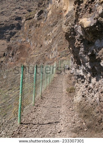 Rocks pathway with fence in the mountain. Vertical format.