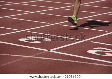 Detail of a male athlete leg crossing the finish line. Horizontal