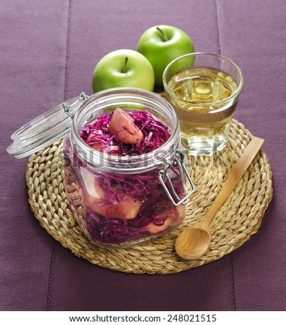 home-made canned red cabbage with apple wine in a glass jar on a wicker stand