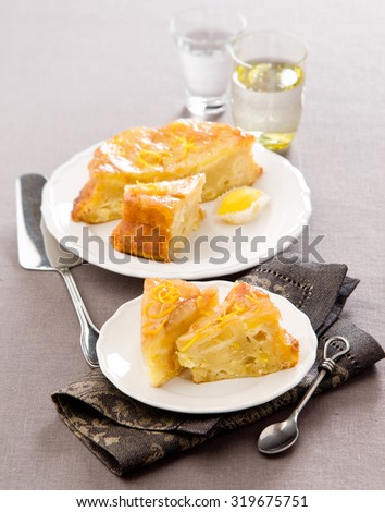 cake with fruit apples pears on a white plate with lemon zest beige linen tablecloth
