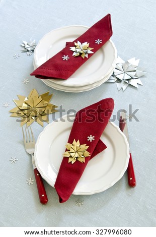 Decor Creative ideas for Christmas holiday table serving origami snowflakes gold silver on white plates red napkin blue tablecloth
