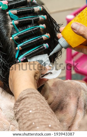 Hairdresser curling the customer. Who come to the salon.