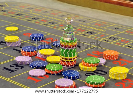 image of a casino roulette grey layout full with chips and the dolly over the winning number