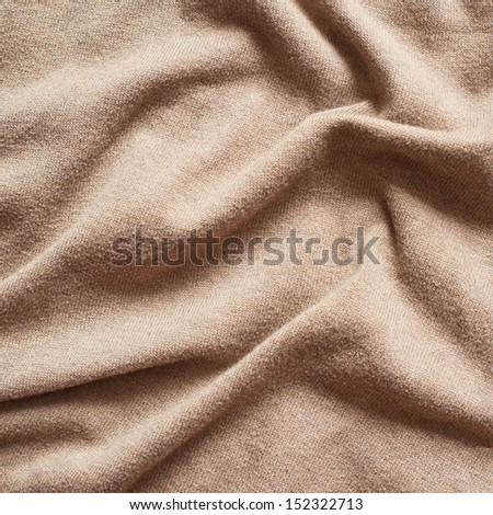 Creased beige cloth material fragment as a background texture