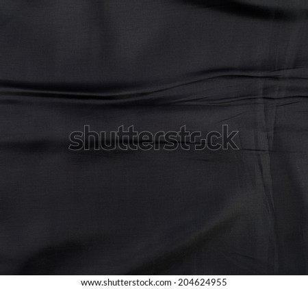 Fragment of a wrinkled black suit\'s lining fabric cloth as a background texture