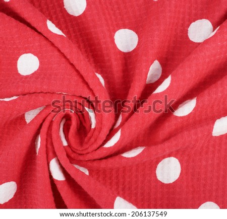 Fragment of a wrinkled red and white polka dot cloth fabric as a background texture