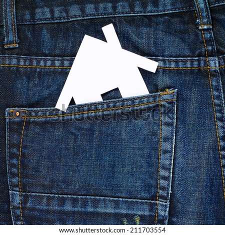 White paper house shape in a back pocket of a navy blue denim jeans as a background composition