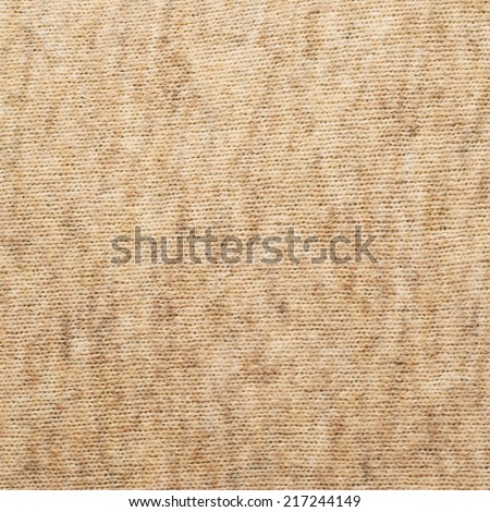 Beige knitted cloth material fragment as a background texture composition
