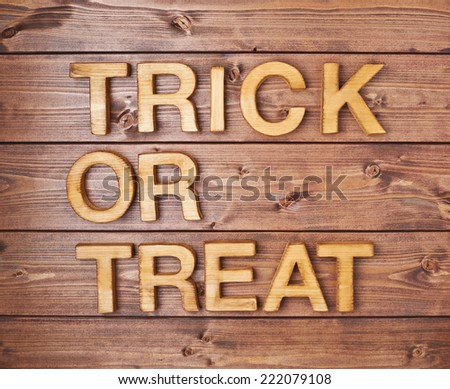 Trick or treat written with wooden letters over the covered with brown boards surface composition