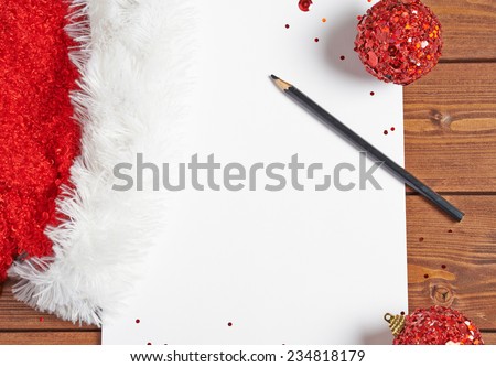 Letter to the Santa Claus composition of the copyspace blank sheet of paper next to multiple Christmas decorations over the wooden surface