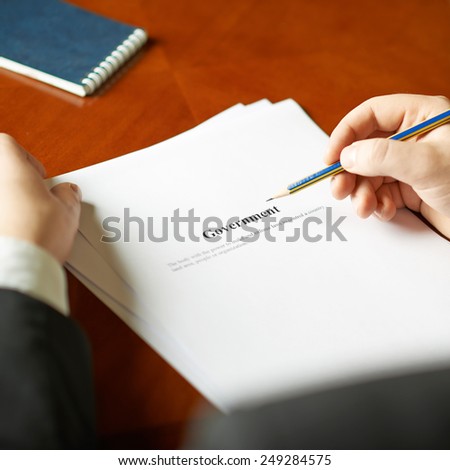Government definition as a shallow depth of field close-up composition of a man in a business suit working with the text