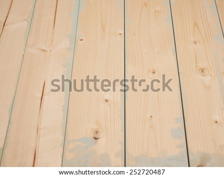 Surface covered with multiple pine wood boards with the paint stains and leaks in the gaps, as an abstract background composition with a shallow depth of field