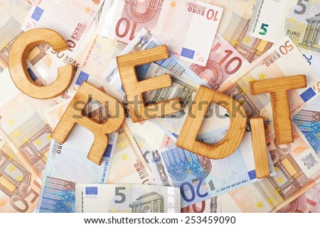 Word Credit over the surface covered with the euro bank note bills