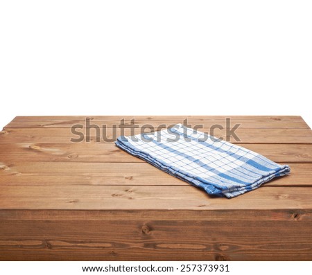 Blue tablecloth or towel over the surface of a brown wooden table, composition isolated over the white background