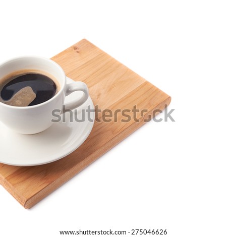 Fresh cup of coffee on a ceramic plate over the wooden serving board, composition isolated over the white background and framed as a close-up copyspace background composition