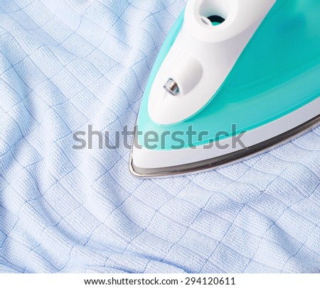 Green iron with blue cloth composition, housework, laundry and housekeeping concept