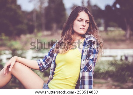 Sad Trendy Hipster Girl Relaxing on the road at the day time. Concept of Modern Youth Lifestyle .
