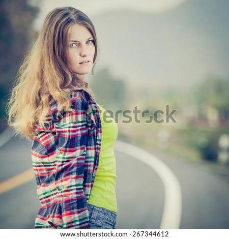 Trendy Hipster Girl Relaxing on the road at the day time. Concept of Modern Youth Lifestyle.