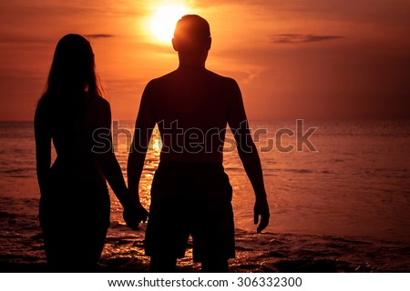 couple in love back light silhouette on sea at the  sunset time