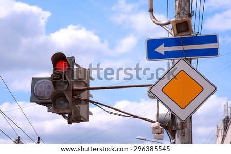 red traffic light in the city and road signs