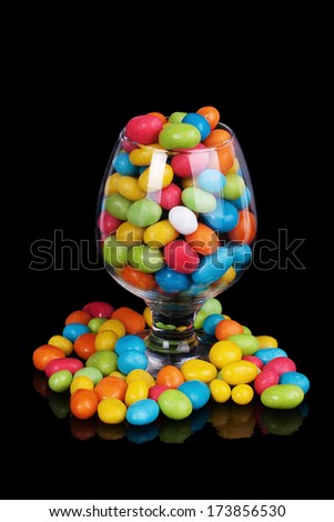 colorful candy in glass isolated on black background