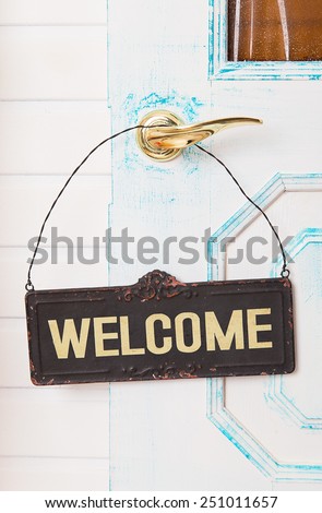 Wooden welcome sign on white door