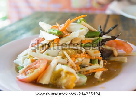 Somtum or Thai green papaya salad with salted egg, dried salted prawns, tomato, and groundnuts
