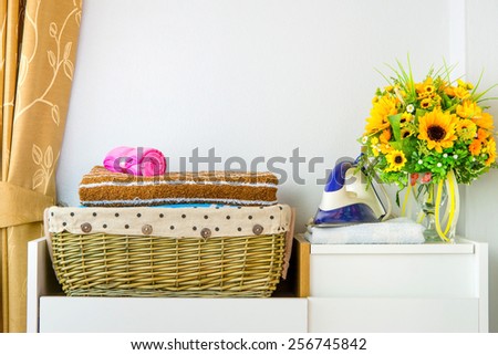Steam iron with clothes in the basket, on white background