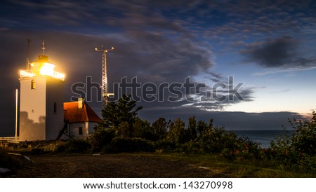 Lighthouse at night with a Scandinavian midsummer night sky in the background