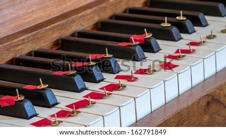 Thumbtack on piano keys making it difficult or painful to play music.  \