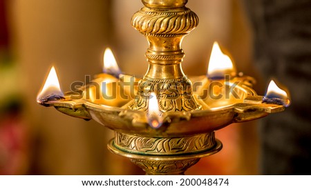 Traditional south indian brass oil lamp \'Nilavilakku \'. During events like housewarming, marriage etc., the Nilavilakku is lighted before starting the rituals. This picture is taken during a wedding