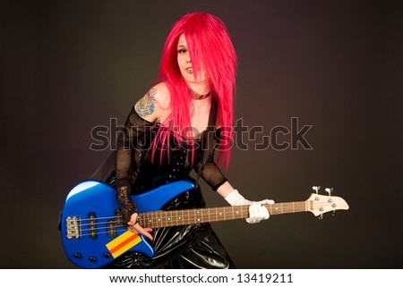 Attractive girl playing bass guitar isolated on black