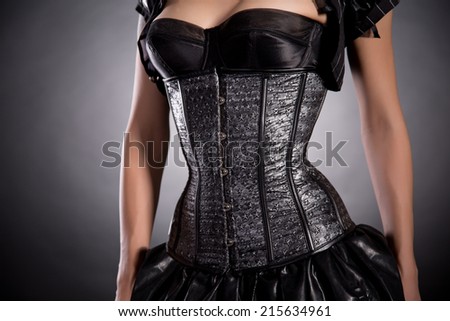 Young woman wearing silver corset with stars, studio shot