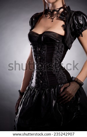 Beautiful young woman in Victorian style costume, studio shot on black background