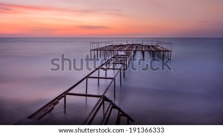 Sunrise on old ocean pier - long exposure unusual background