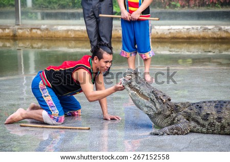 Guangzhou, China - February 27: Show on crocodile farm.An unidentified man doing dangerous stunts.Guangzhou croco farm, one of the largest farms in South China.On February 27, 2013 in Guangzhou