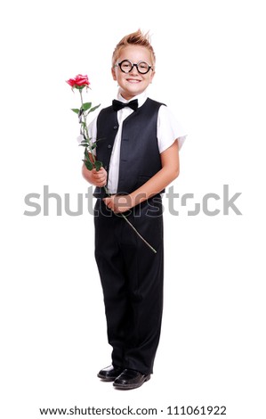 Full length portrait of a boy in suit and bow tie holding a rose