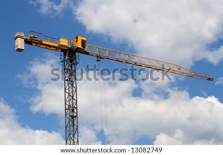 lifting crane under blue sky with clouds