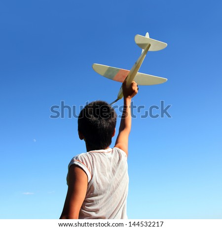 happy boy running airplane model under blue sky