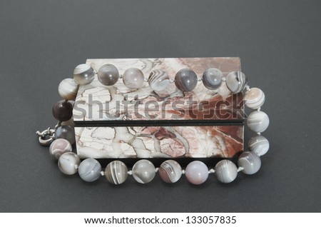 Stone box with the beads on a gray background.