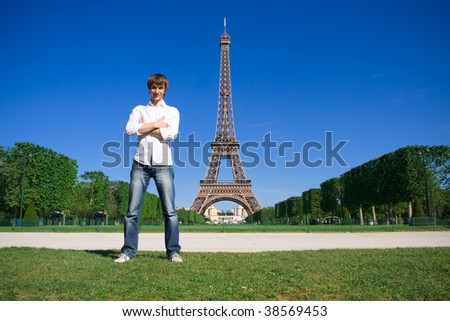 Young man standing on the Champs de Mars. Eiffel tower in background