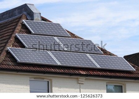 Solar photovoltaic panels mounted on a tiled house roof