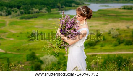 portrait of a beautiful girl in the Greek manner in a field of flowers