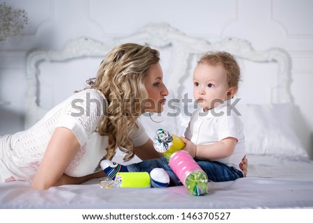 Mom with her son. Beautiful curly-haired boy with a big candy in the hands of