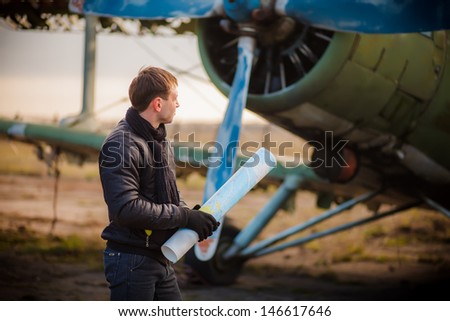 a love story. portrait of a young man who dreams of traveling. exploring the world map. meeting at a retro airplane.