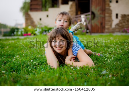 happy boy hugging his mother in the summer garden
